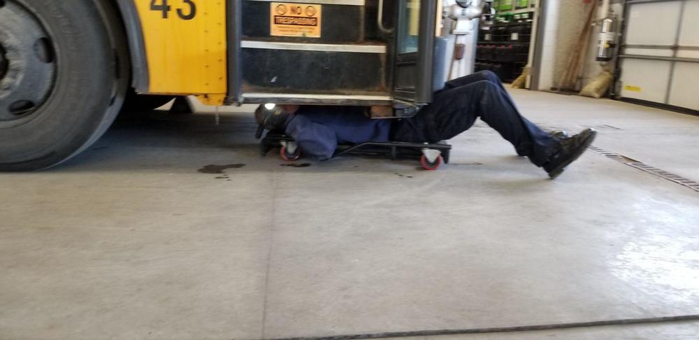 State Police Officer inspecting under the bus. 