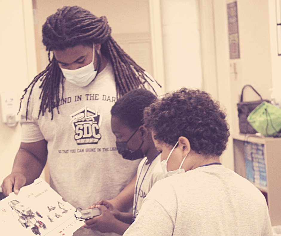 Photo of Sheldon Day and two students enjoying a STEM activity while at Sheldon's Daylight Camp for youth grades 4-6.