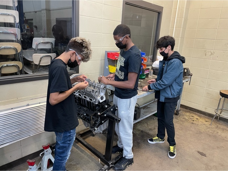 Students disassembling an engine in Auto Service